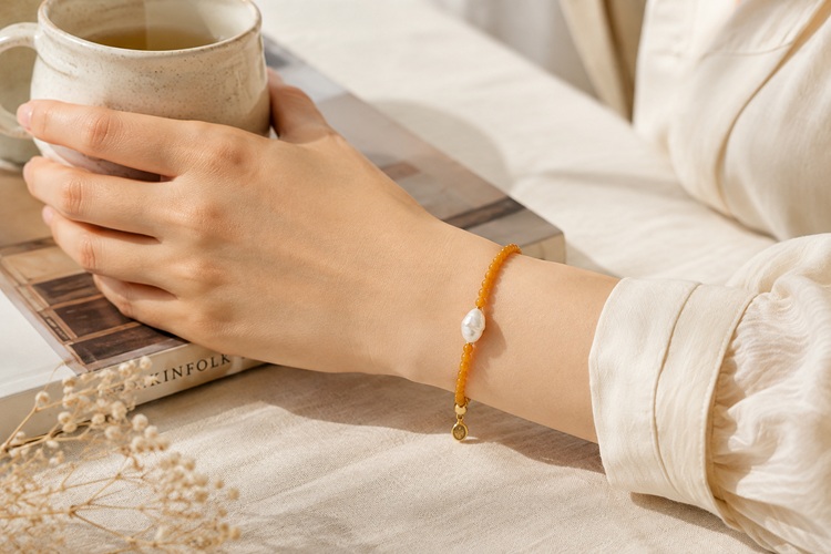 Yellow jade and baroque pearl bracelet styled with a neutral outfit
